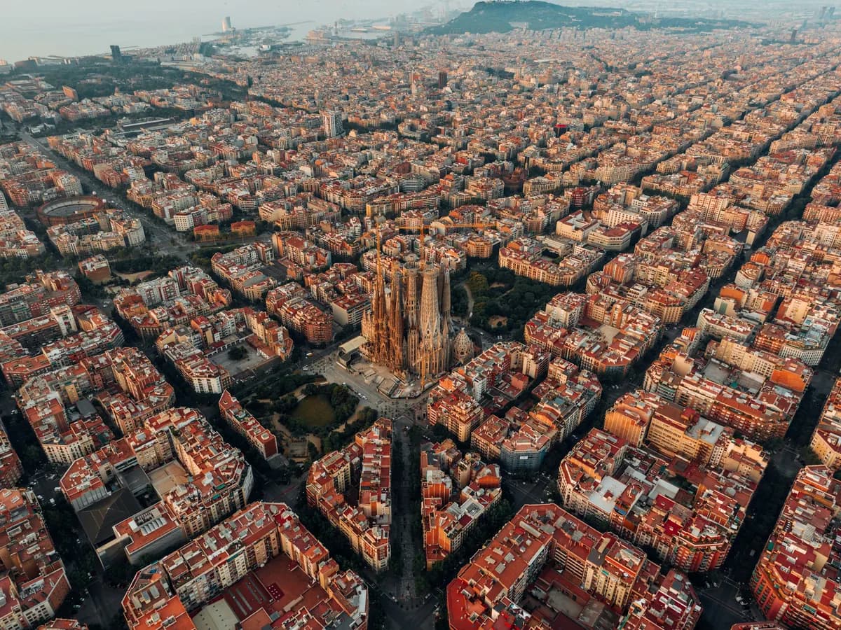 Aerial view of Barcelona with the Sagrada Família among dense city blocks.
