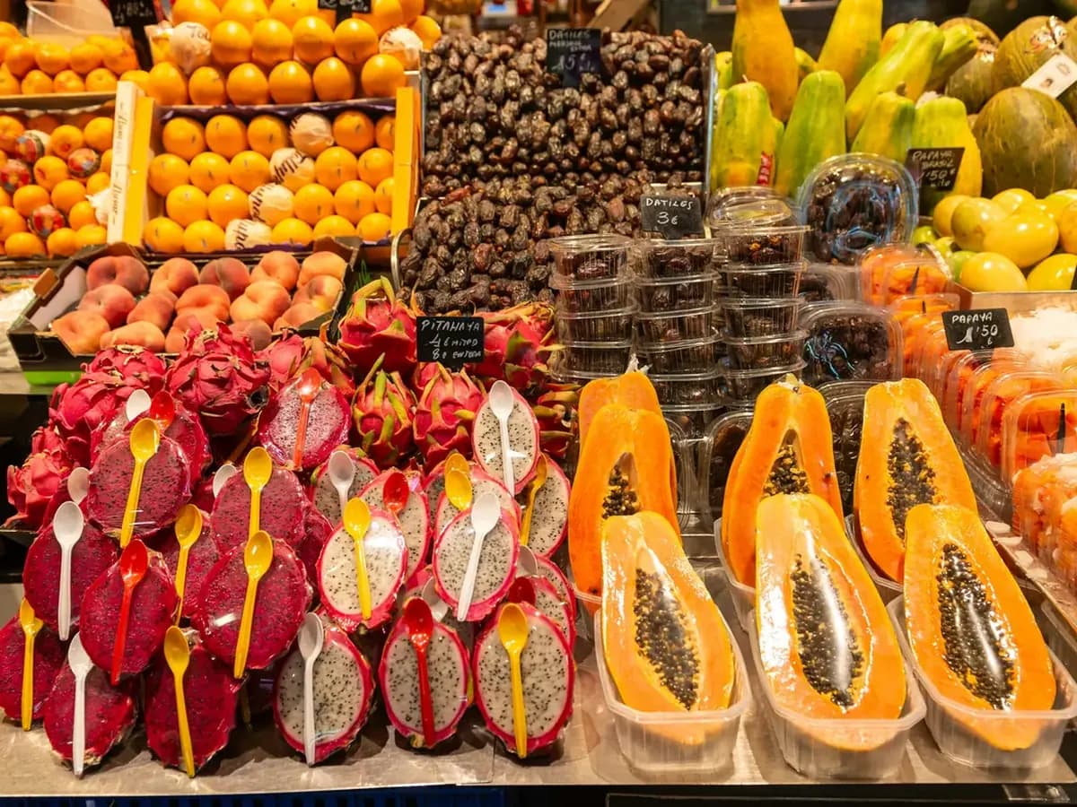 Colorful cut fruit arranged at a Barcelona market stall.