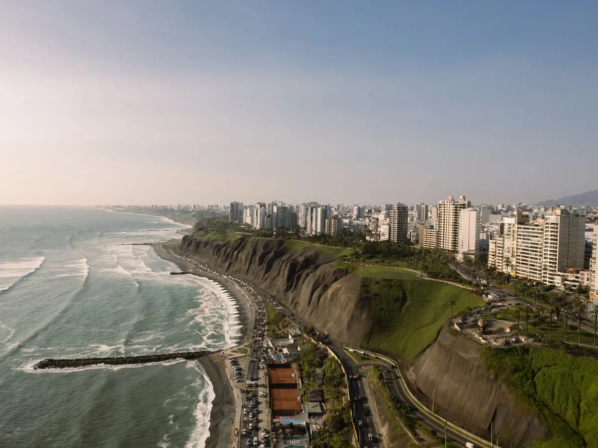 Aerial view of Lima's Pacific coastline, cliffs, and city buildings.